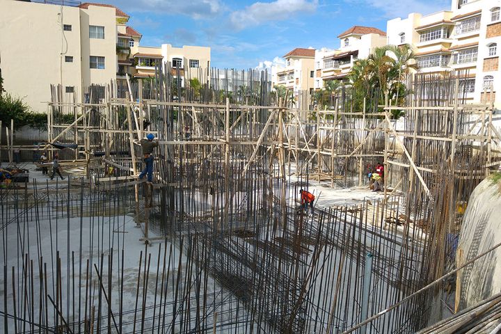 A forest of column rebar rising from the already poured foundation slab