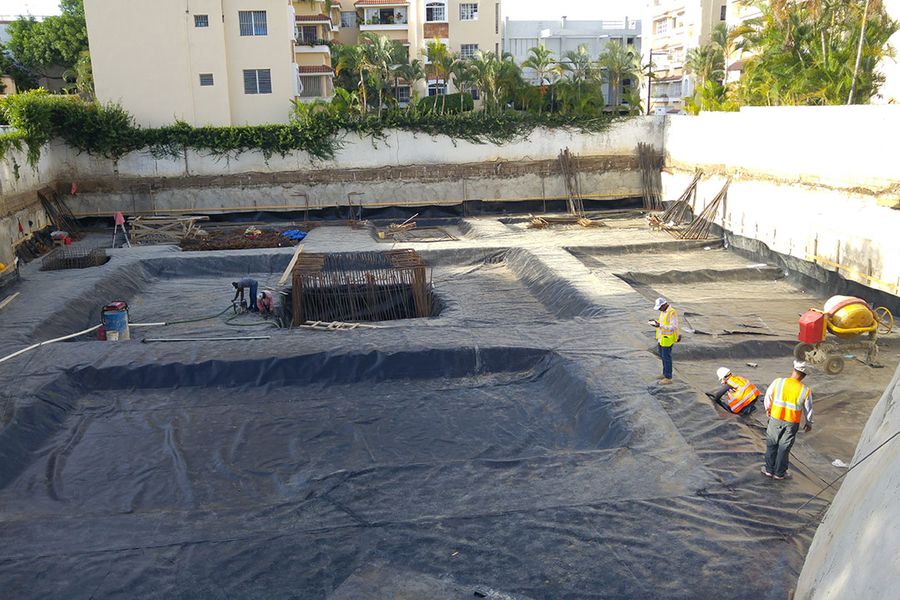 Excavation on a construction site with the waterproofing membrane in place and the footings laid out