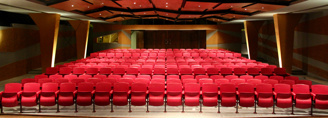 Auditorium achevé, avec fauteuils rouges et plafond en bois